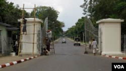 Công nhân sửa chữa cổng vào trường Đại học Rangoon ở Miến Điện.