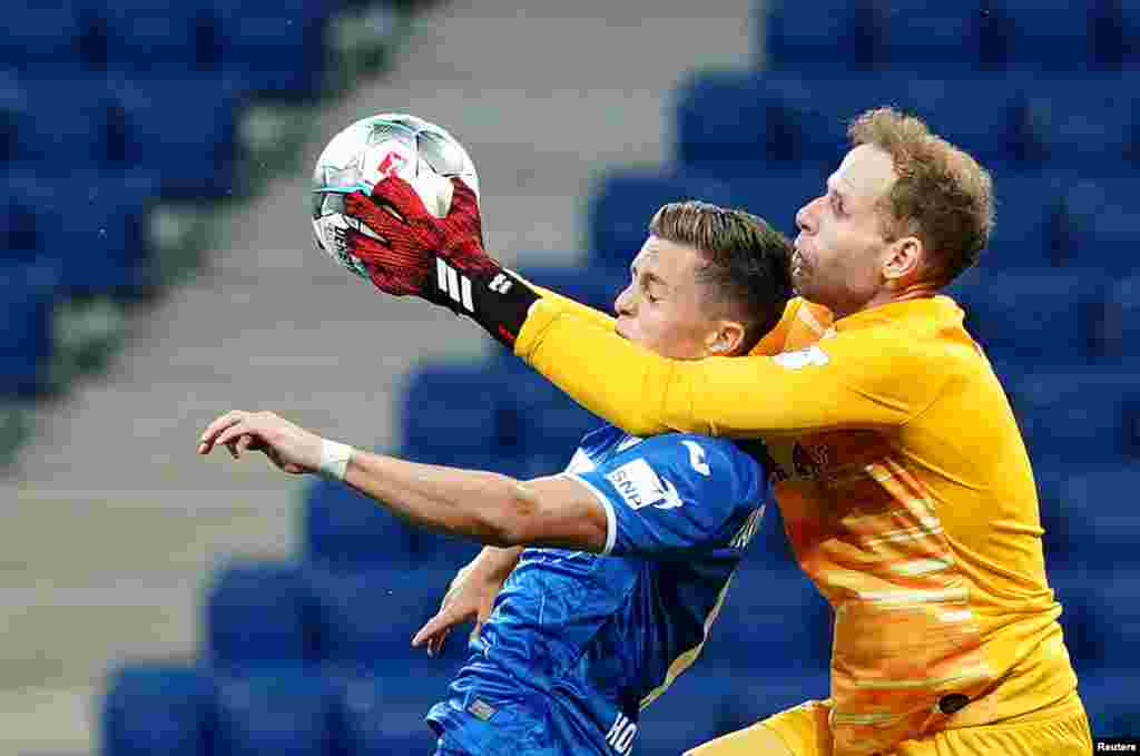 Hoffenheim&#39;s Christoph Baumgartner vies for the ball with Leipzig&#39;s Peter Gulacsi, in Sinsheim, Germany, June 12, 2020.