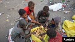 Boys eat bread they collected from a garbage dump on the outskirts of the Red Sea port city of Hodeida, Yemen January 7, 2018. 