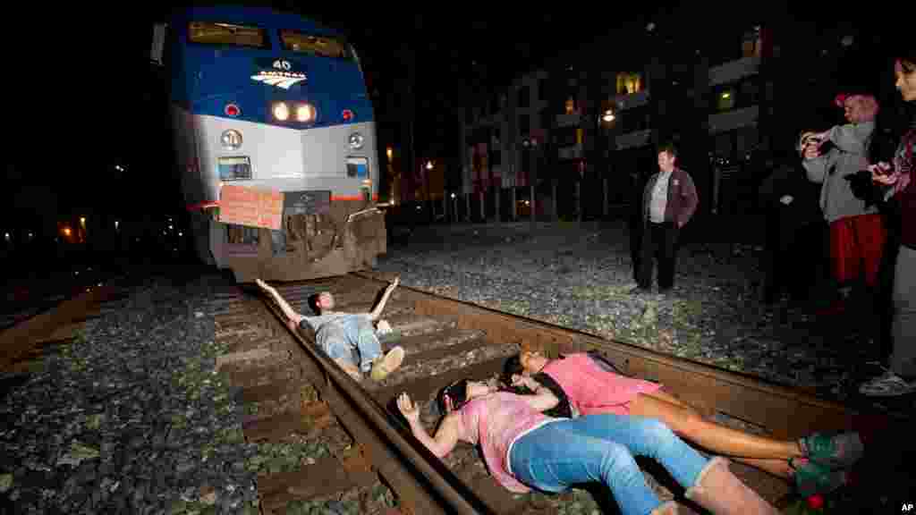 Protesters block an Amtrak train as hundreds protest recent grand jury decisions not to indict white police officers in the deaths of black men in Berkeley, Calif., on Monday, Dec. 8, 2014. 