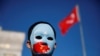 FILE - An ethnic Uighur boy wears a mask during a protest against China in Istanbul, Turkey, Dec. 14, 2019. 