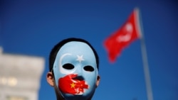 FILE - An ethnic Uighur boy wears a mask during a protest against China in Istanbul, Turkey, Dec. 14, 2019.