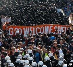 Manifestantes vestidos de negro se enfrentan con la policía alemana durante una protesta titulada "G20 Bienvenido al infierno", contra la Cumbre del Grupo de los Veinte en Hamburgo. Julio 7 de 2017.