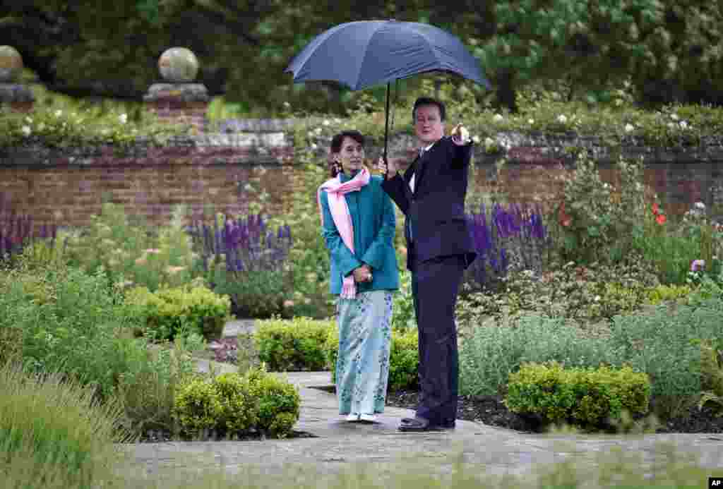 Aung San Suu Kyi and British Prime Minister David Cameron walk in the Rose Garden at the Prime Minister's country residence Chequers, near Ellesborough, Buckinghamshire, England, June 22, 2012.