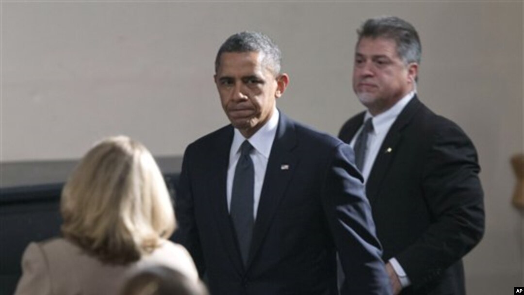 Tổng thống Obama (giữa) đến thị trấn Newtown vào lúc bắt đầu buổi lễ liên tôn, cầu nguyện cho các nạn nhân trong vụ cuồng sát tại Trường Tiểu học Sandy Hook, ở Newtown, bang Connecticut 16/12/12
