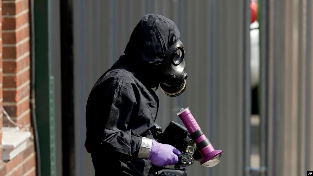 Un especialista de la policía en traje de protección sale de John Baker House un lugar para personas sin hogar en Rollestone Street en Salisbury, Inglaterra, el viernes 6 de julio de 2018. Una de dos personas contaminadas con un agente neurotóxico falleció el domingo. (AP Photo / Matt Dunham)