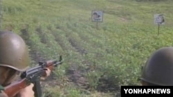 북한 인민보안국 소속 군인들이 이명박 한국 대통령의 그림과 실명이 그려진 포적지에 사격훈련을 하고 있다. '조선중앙TV' 방영.