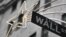 A holiday decoration is seen over Wall St. sign outside the New York Stock Exchange, November 27, 2012.