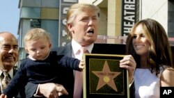 Donald Trump, le milliardaire développeur et producteur de NBC "The Apprentice", avec sa femme, Melania Knauss, et leur fils, Barron, posent pour une photo après qu'il a été honoré avec une étoile sur le Hollywood Walk of Fame à Los Angeles, mardi 16 janvier 2007.