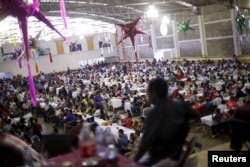 Migrants take part in a lunch event during the 10th annual celebration of migrant carnival workers in Tlapacoyan, Mexico, Dec. 14, 2015.