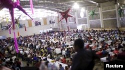 FILE - Migrants take part in a lunch event during the 10th annual celebration of migrant carnival workers in Tlapacoyan, Mexico, Dec. 14, 2015. 