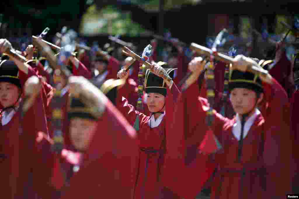 University students dressed in traditional costumes perform during the grand Confucian ceremony of Seokjeon at a shrine at Sungkyunkwan University in Seoul, South Korea. Seokjeon is a biannual ritual to consecrate Chinese philosopher Confucius and his disciples as supreme teachers at civil temples.