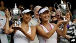 Su-Wei Hsieh of Taiwan, left, and Shuai Peng of China pose with their trophies after winning against Ashleigh Barty of Australia and Casey Dellacqua of Australia in the Women's doubles final match at the All England Lawn Tennis Championships in Wimbledon,