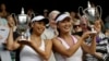 Su-Wei Hsieh of Taiwan, left, and Shuai Peng of China pose with their trophies after winning against Ashleigh Barty of Australia and Casey Dellacqua of Australia in the Women's doubles final match at the All England Lawn Tennis Championships in Wimbledon,