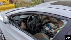 This May 21, 2020, photo shows a parked car with a broken driver's side window after a smash-and-grab break-in in Los Angeles, where vehicle larcenies shot up nearly 17% in the coronavirus pandemic.