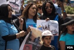 Protesters hold signs and sing at a rally in support of the Sudan's revolution, in Chicago, Illinois, June 29, 2019. (J. Patinkin/VOA)
