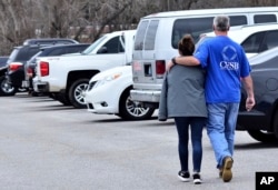 FILE - Family members escort their children out of Marshal North Middle School near Palma, Ky., Jan. 23, 2018, after the students were taken there from Marshal High School.