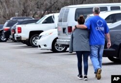 FILE - Family members escort their children out of Marshal North Middle School near Palma, Ky., Jan. 23, 2018, after the students were taken there from Marshal High School.