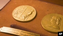 FILE - This undated photo shows the front and back sides of the medal awarded for the Pulitzer Prizes in New York. 