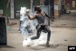 A protester throws a tear gas canister back at Kenyan police officers amid clashes during an anti-government demonstration called following deadly nationwide protests over tax increases, in downtown Nairobi on July 2, 2024.