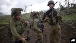 Israeli soldiers of the Golani brigade adjust their weapons during training near the border with Syria in the Israeli-controlled Golan Heights, Feb. 26, 2014. 