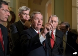 FILE - Sen. Lindsey Graham, R-S.C., joined by, from left, Sen. John Barrasso, R-Wyo., Sen. Bill Cassidy, R-La., and Senate Majority Leader Mitch McConnell, R-Ky., speaks to reporters as they faced assured defeat on the Graham-Cassidy bill, the GOP's latest attempt to repeal the Obama health care law, at the Capitol in Washington, Sept. 26, 2017.