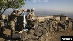 A member of the United Nations Disengagement Observer Force (UNDOF) looks through binoculars at Mount Bental, an observation post in the Golan Heights overlooking the Syrian side of the Qunietra crossing, Aug. 31, 2014.