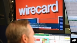 A stockbroker sits in front of a screen with news about Wirecard at the Frankfurt Stock Exchange in Frankfurt, Germany, as two accounts that were supposed to contain 1.9 billion euros (2.1 billion dollars) probably don’t exist, June 22, 2020.
