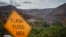 In this photo provided by Santa Barbara County Fire Department, a flash flood area sign is posted, as evacuations have been issued for several fire-ravaged communities in Santa Barbara, California, Jan. 8, 2018. 