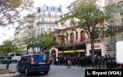 FILE - A crowd of mourners and journalists in front of the Bataclan concert hall.