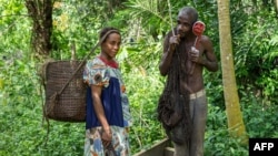 FILE - Members of the Bagyeli Pygmy community display their hunting equipment, May 26, 2017 in the Kribi region, Cameroon.