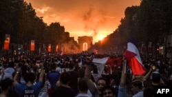 People celebrate France's victory in the Russia 2018 World Cup final football match between France and Croatia, on the Champs-Elysees avenue in Paris on July 15, 2018.