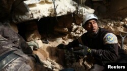 Civil defense members look for survivors under rubble of damaged buildings after airstrikes on the northern neighborhood of Idlib city, Syria, Dec. 5, 2016.