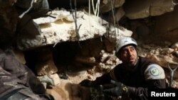在叙利亚城市里，民兵们在空袭的废墟中寻找幸存者（2016年12月5日）