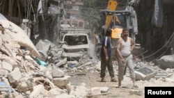 Residents inspect a damaged site after an airstrike on Aleppo's rebel held Al-Mashad neighborhood, July 26, 2016. 