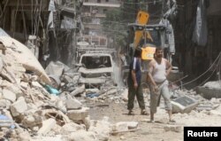 Residents inspect a damaged site after an airstrike on Aleppo's rebel held Al-Mashad neighborhood, July 26, 2016.