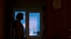 Seorang perempuan yang dipukuli suaminya, melihat melalui jendela di tempat penampungan perempuan korban kekerasan dalam rumah tangga, 26 Januari 2017. (Foto: AP)