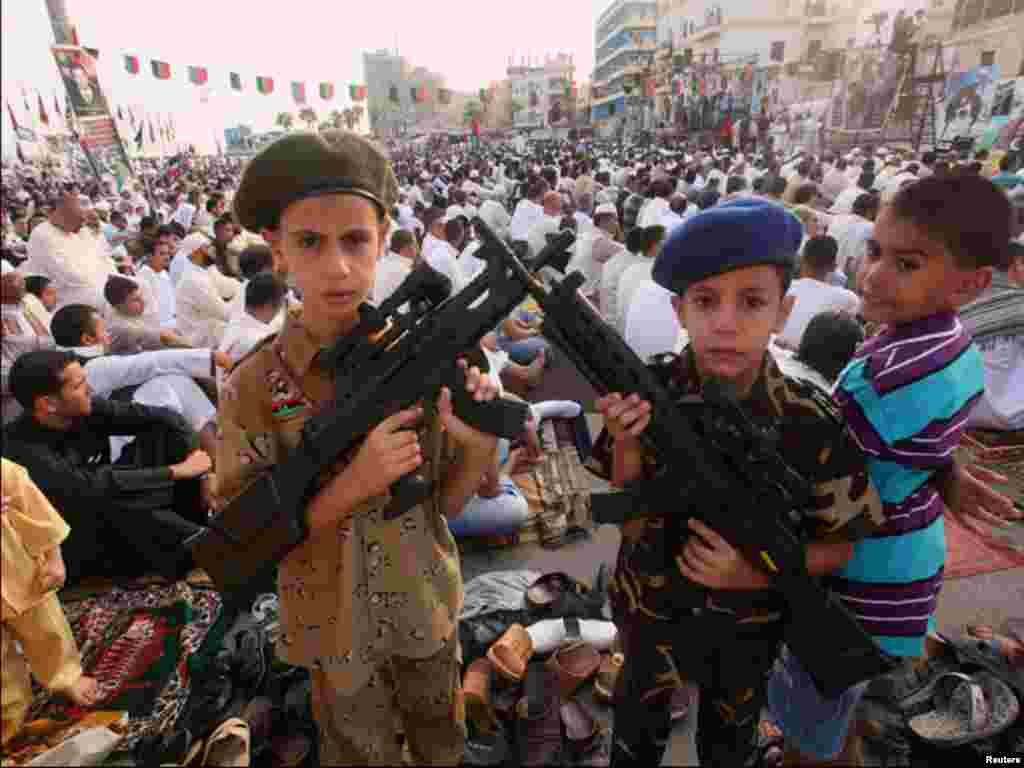 لیبیا میں عیدالفطر کی نماز کی ادائیگی کے دوران دو بچے کھلونا پستول تھامے ہوئے ہیں۔
