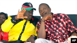 The National Alliance Party presidential candidate Deputy Prime Minister Uhuru Kenyatta right, and his running mate William Ruto, talk during a rally at Uhuru Park, in Nairobi, January 12, 2013. 