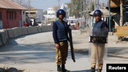 Policemen keep guard near the central prison where a court convicted 31 people over the campus lynching of a university student last year who was falsely accused of blasphemy, in Haripur, Pakistan, Feb. 7, 2018.