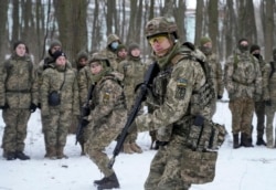 Anggota Pasukan Pertahanan Teritorial Ukraina, unit militer sukarelawan Angkatan Bersenjata, berlatih di taman kota di Kyiv, Ukraina, 22 Januari 2022. Puluhan warga sipil telah bergabung dengan tentara cadangan Ukraina dalam beberapa pekan terakhir di tengah kekhawatiran akan invasi Rusia. (AP)