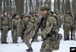 Members of Ukraine's Territorial Defense Forces, volunteer military units of the Armed Forces, train in a city park in Kyiv, Ukraine, Jan. 22, 2022. Many civilians have been joining Ukraine's army reserves in recent weeks.