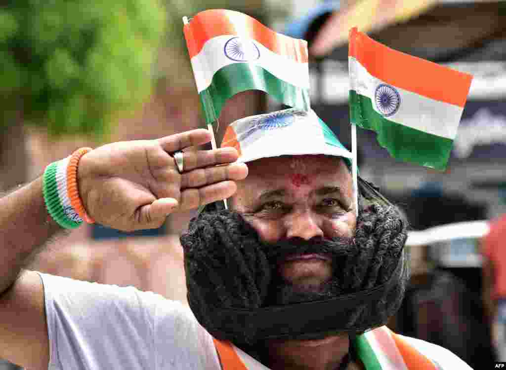 Um homem com um bigode de 8.5 metros posa com a bandeira indiana, na cidade de Bikaner, para comemorar 73 anos de independência da Grã Bretanha.