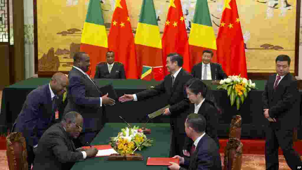 Le président chinois Xi Jinping, et son homologue de la république du Congo Denis Sassou Nguesso et d&#39;autres responsables des deux pays signent des documents lors de la cérémonie à Beijing, en Chine, le 5 juillet 2016.