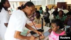 Une infirmière osculte une femme enceinte dans une maternité du district d'Obio à Port Harcourt, au Nigeria, le 24 mars 2011. (REUTERS/Akintunde Akinleye)