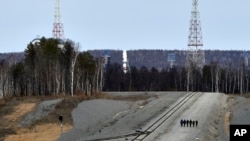 A Russian Soyuz rocket, center in the background, carrying satellites stands on the launch pad at the new Vostochny Cosmodrome near Uglegorsk, the city in eastern Siberia in the Amur region, Russia, April 27, 2016.