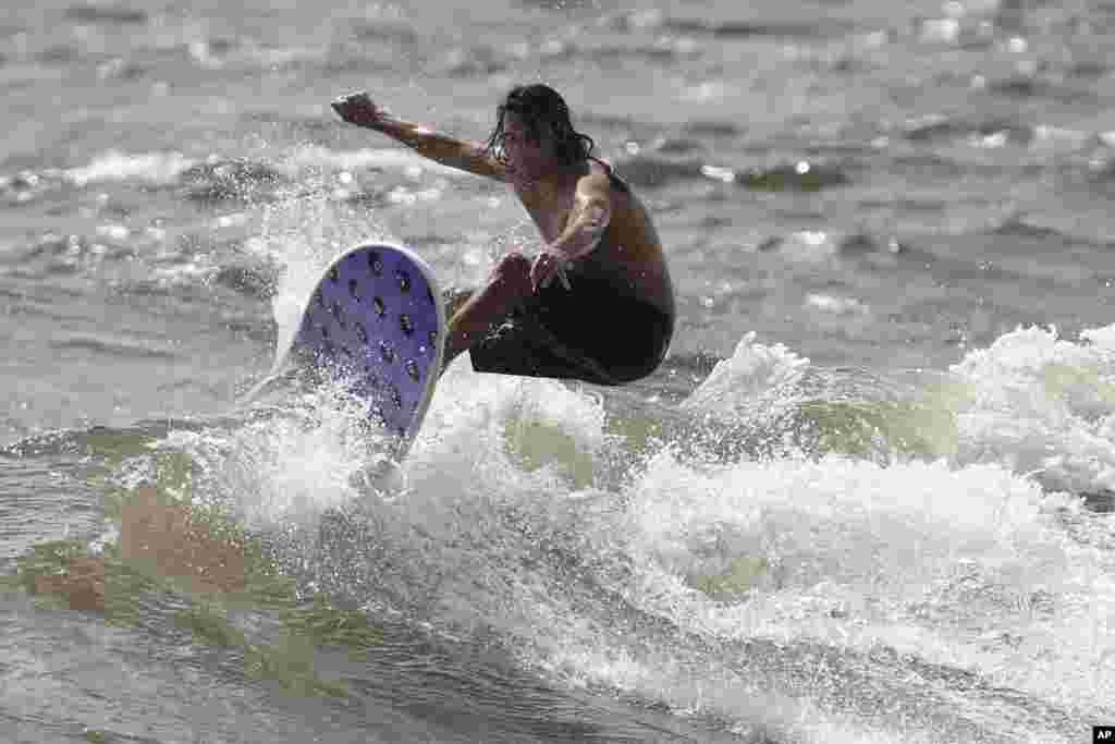 Un hombre practica surf en la playa de Lake Worth, Florida, antes que el huracán Dorian llegue al estado. Sábado 31 de agosto de 2019. Los meteorólogos dicen que Dorian podría afectar la costa este de Florida. AP/Lynne Sladky. &nbsp;