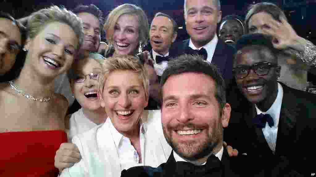 This image released by Ellen DeGeneres shows actors front row from left, Jared Leto, Jennifer Lawrence, Meryl Streep, Ellen DeGeneres, Bradley Cooper, Peter Nyong'o Jr., and, second row, from left, Channing Tatum, Julia Roberts, Kevin Spacey, Brad Pitt, Lupita Nyong'o and Angelina Jolie as they pose for a "selfie" portrait on a cell phone during the Oscars at the Dolby Theatre in Los Angeles, California, Mar. 2, 2014.