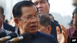 Cambodia's Prime Minister Hun Sen delivers a speech to passengers after they disembarked from the MS Westerdam, owned by Holland America Line, at the port of Sihanoukville, Cambodia, Friday, Feb. 14, 2020. (AP Photo/Heng Sinith)