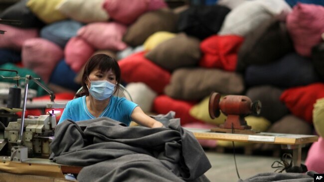 一名台湾志愿者在台北的慈济基金会工厂用再生塑料制作毯子。(资料照片)